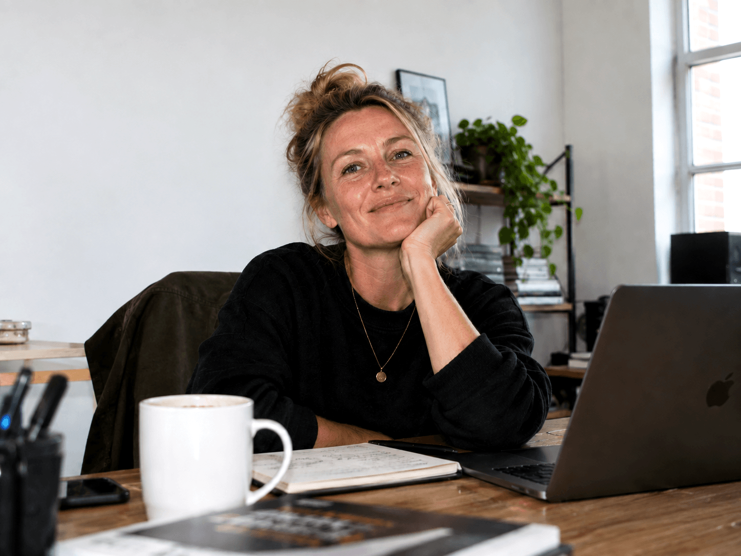 A business owner at her desk, laptop open, considering the question.