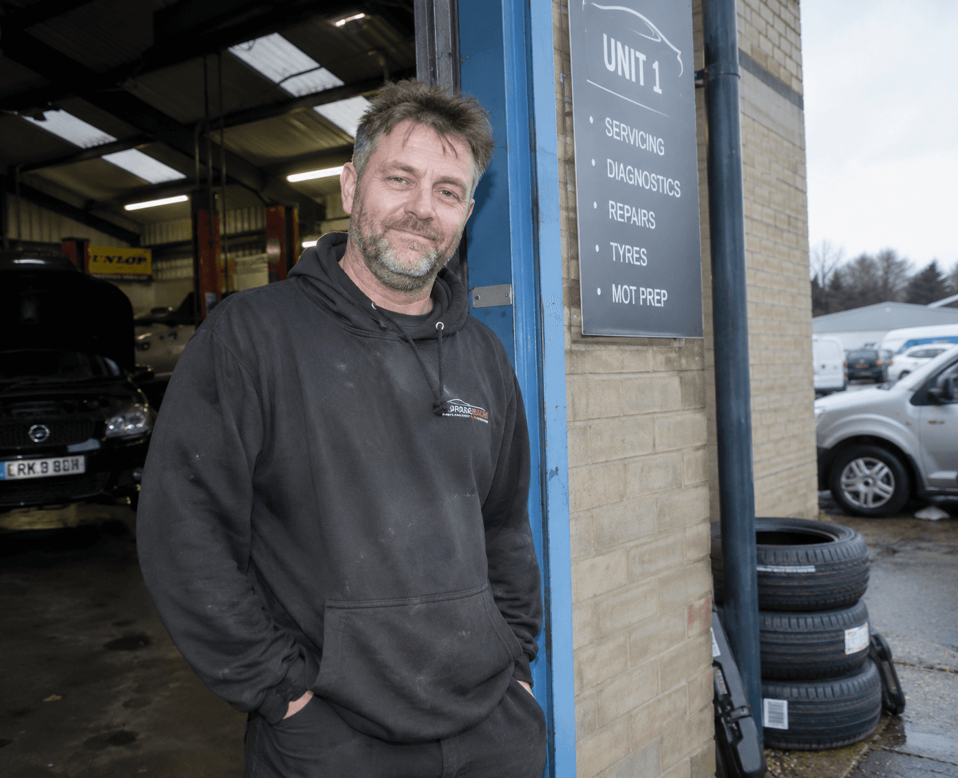 A garage owner outside his workshop.